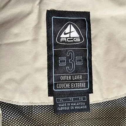 Close-up of a label on a beige jacket with text and a logo.